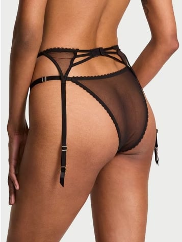 Back view of a women wearing Victoria's Secret black transparent Garters and Hosiery bottom piece on a light grey backround 